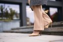 close up of nude heels walking down stairs