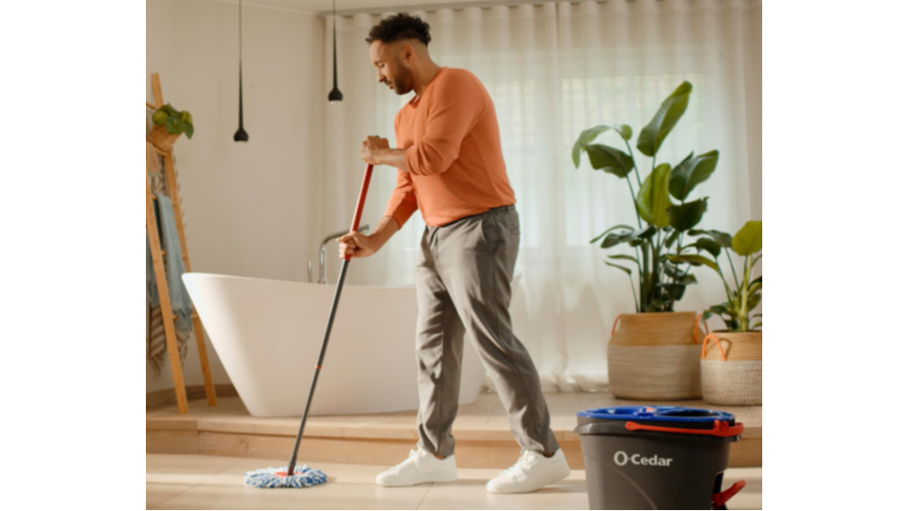 A man using a mop on hardwood flooring