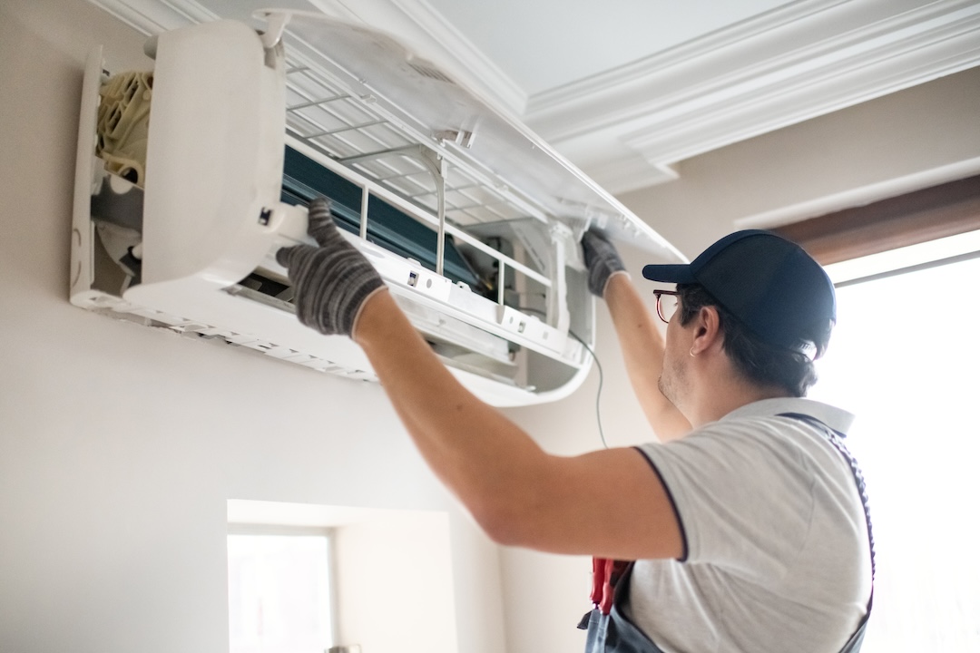 Technician repairing air conditioner at home