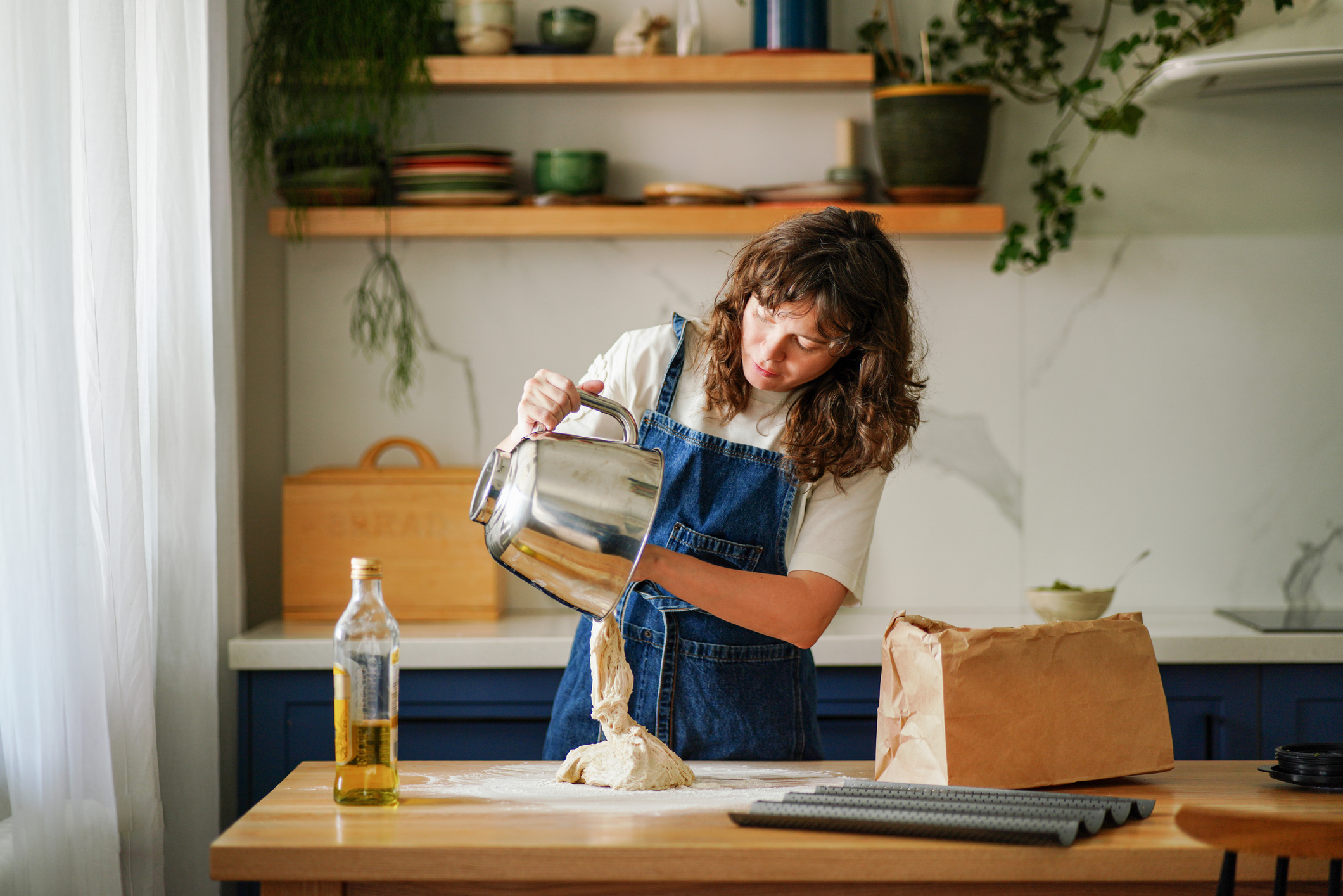 A woman making bread batter in her home.