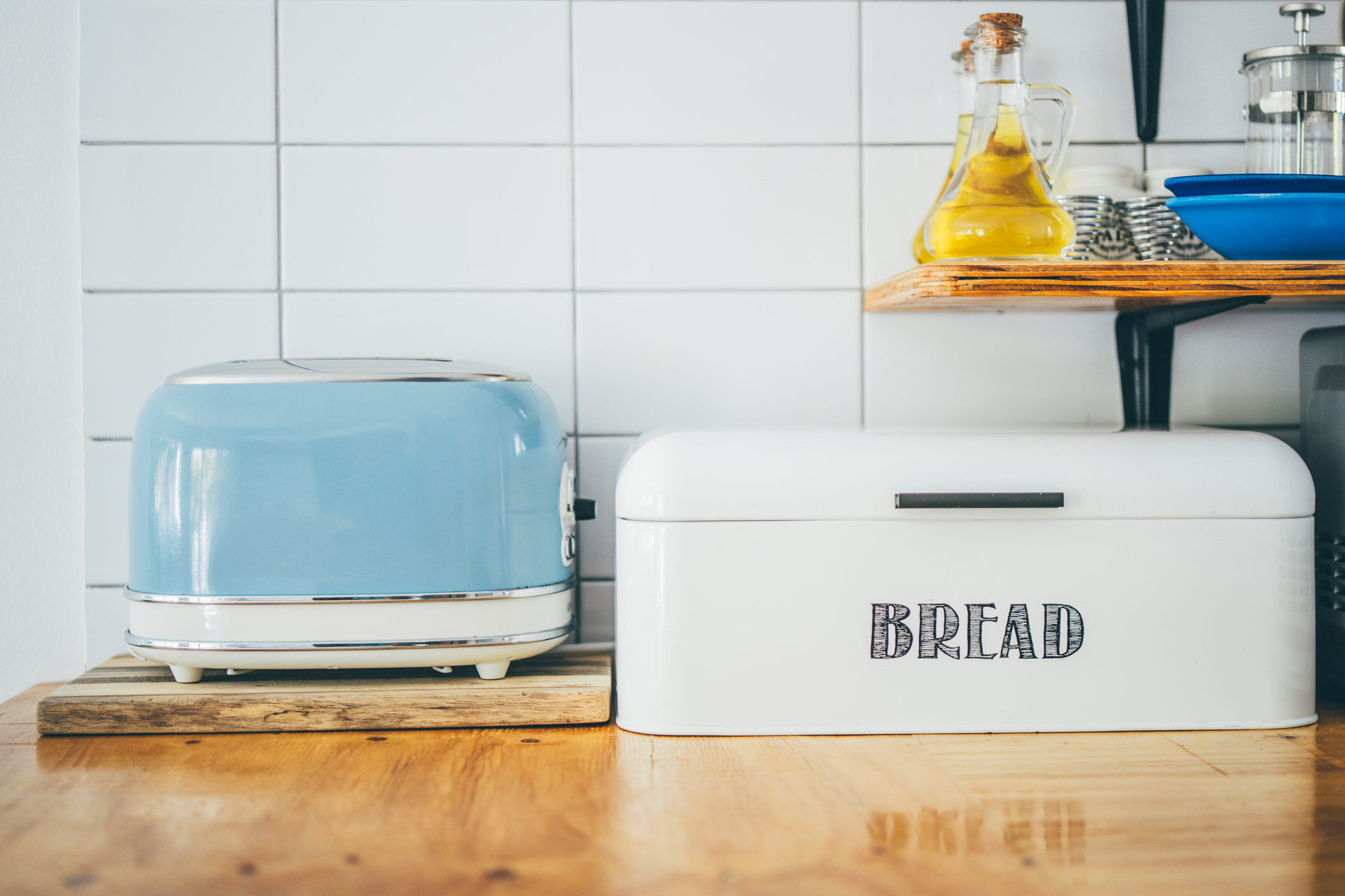 A toaster oven and a bread box in a kitchen.
