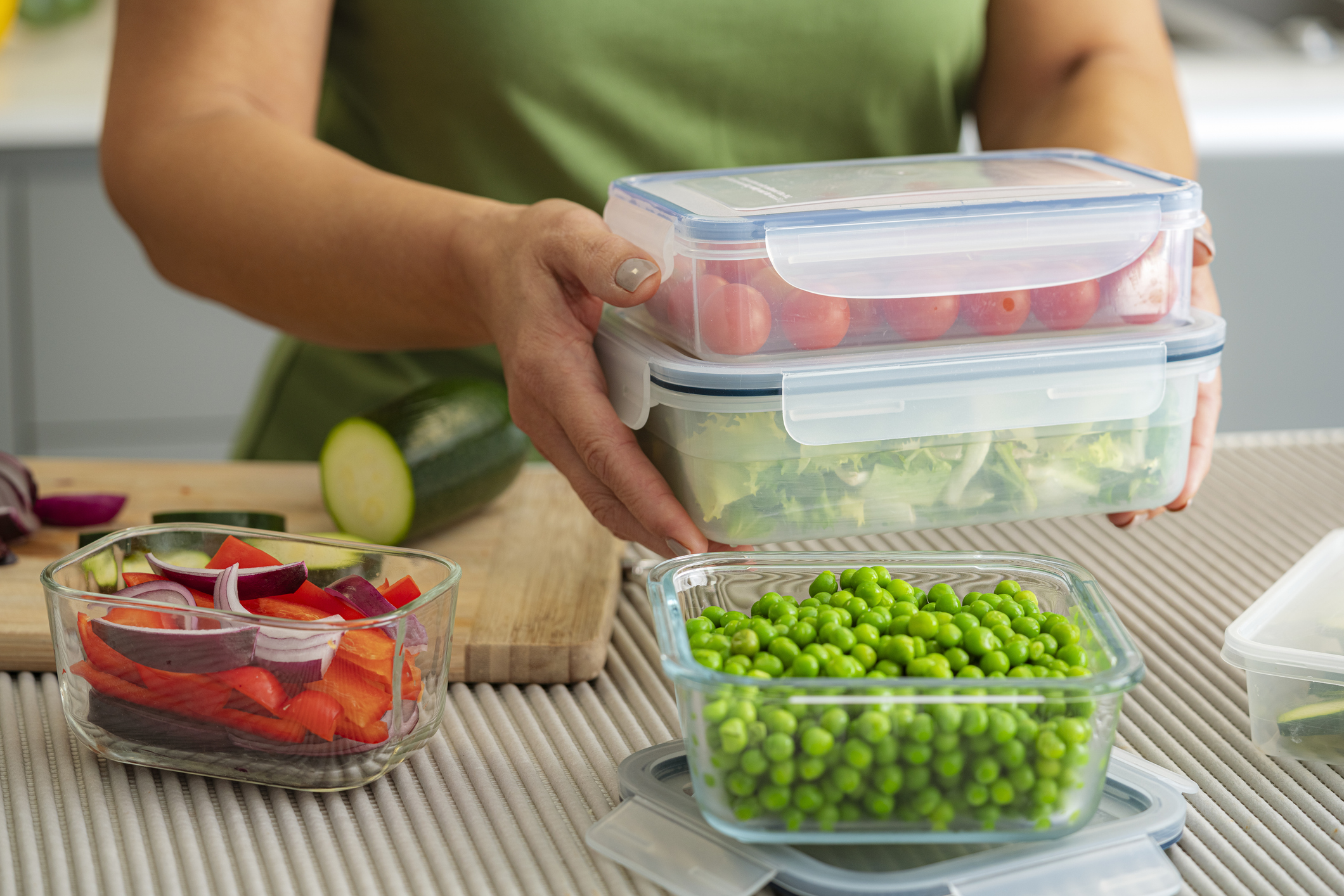 Woman holding plastic airtight food containers filled with vegetables ready for be stored in the refrigerator.High resolution 42Mp indoors digital capture taken with Sony A7rII and Sony FE 90mm f2.8 macro G OSS lens