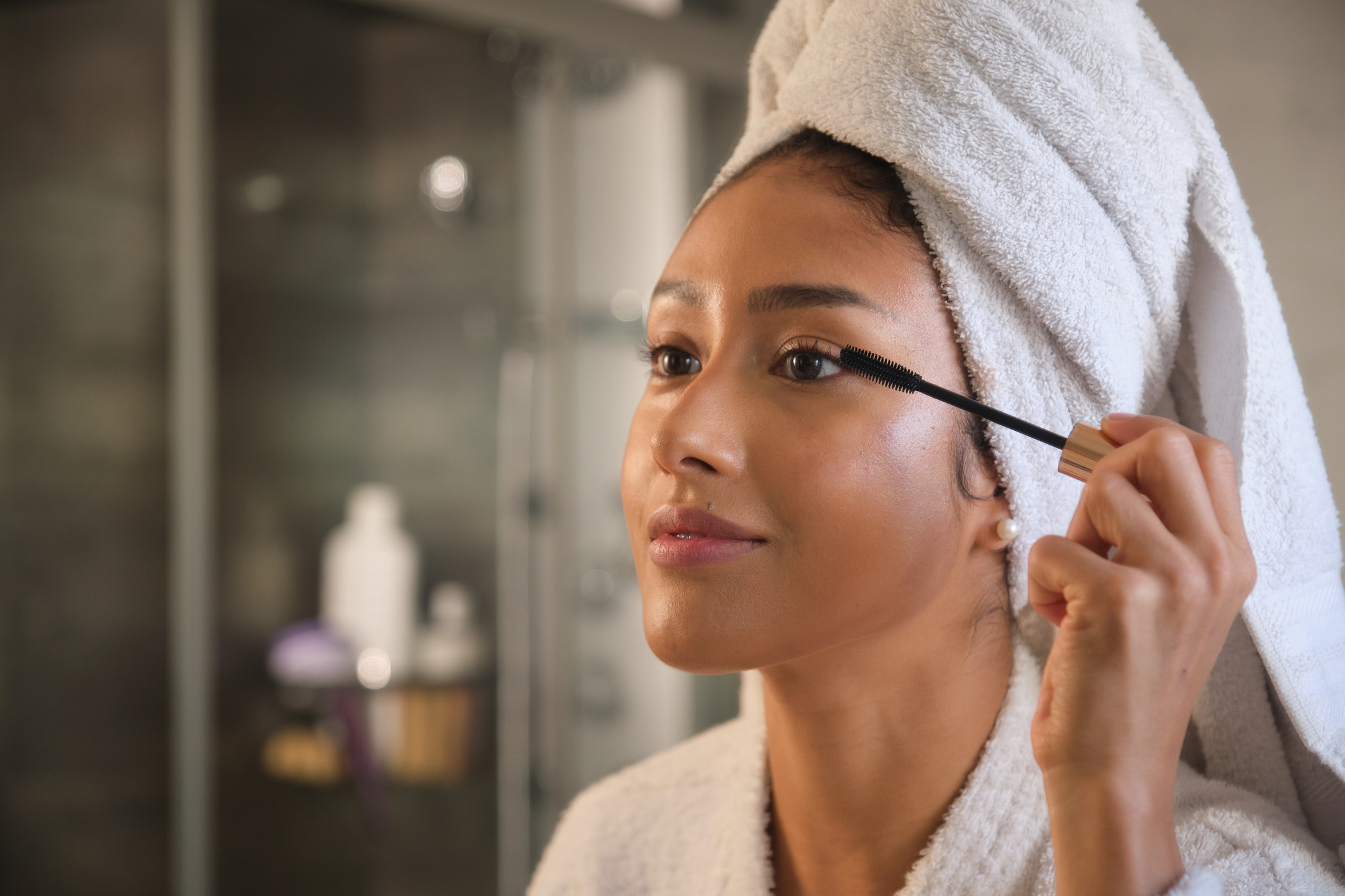 Young woman applying mascara