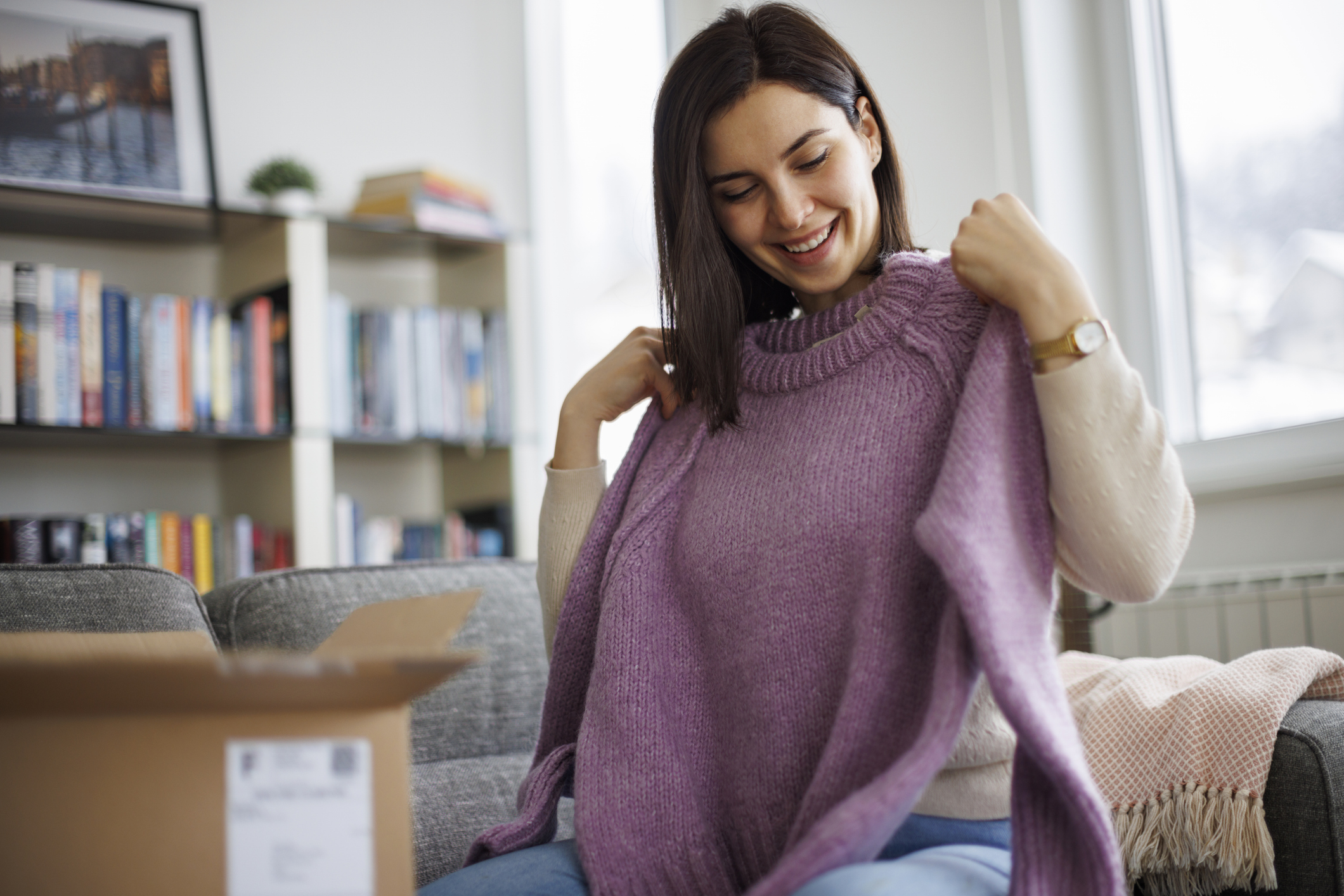 woman holding up sweater
