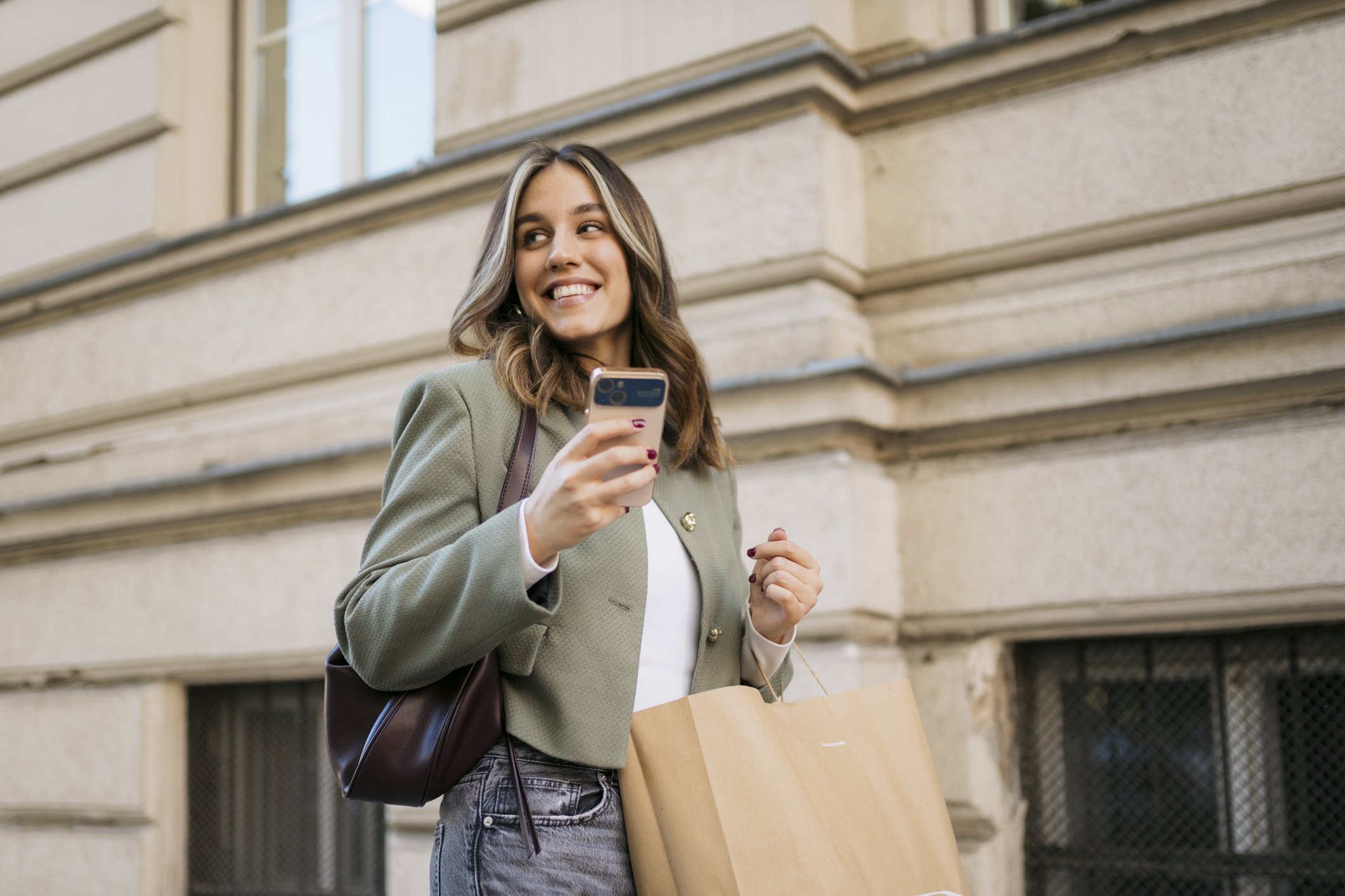 woman holding phone and shopping bag