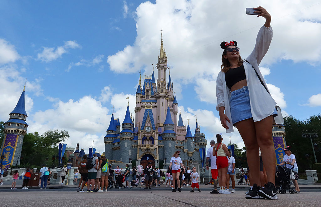 A woman takes a selfie before Cinderella's Castle at the Magic Kingdom Park at Walt Disney World on April 3, 2025, in Orlando, Florida
