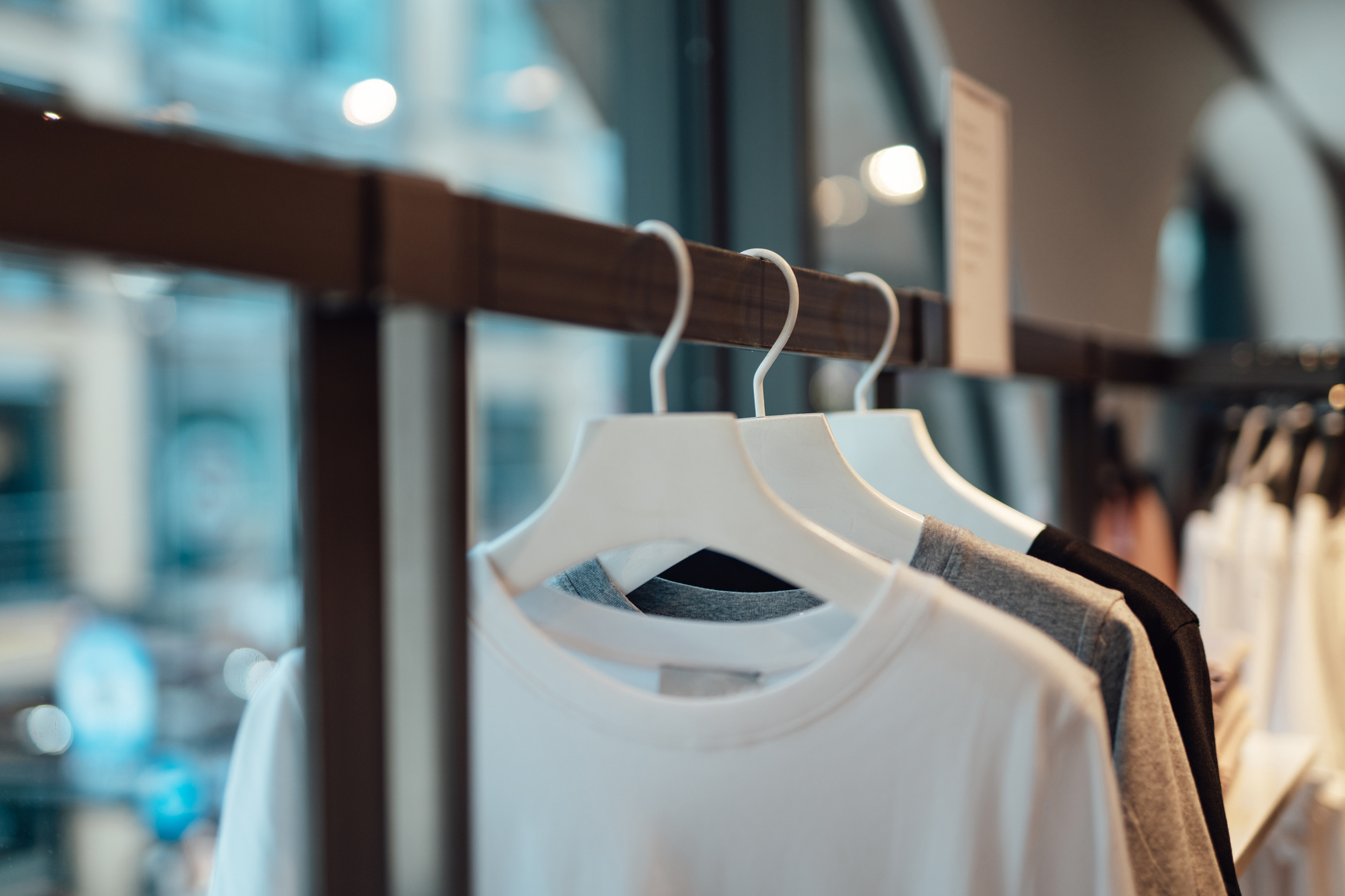 Close-up shot of clothes hanging on rack in fashion store