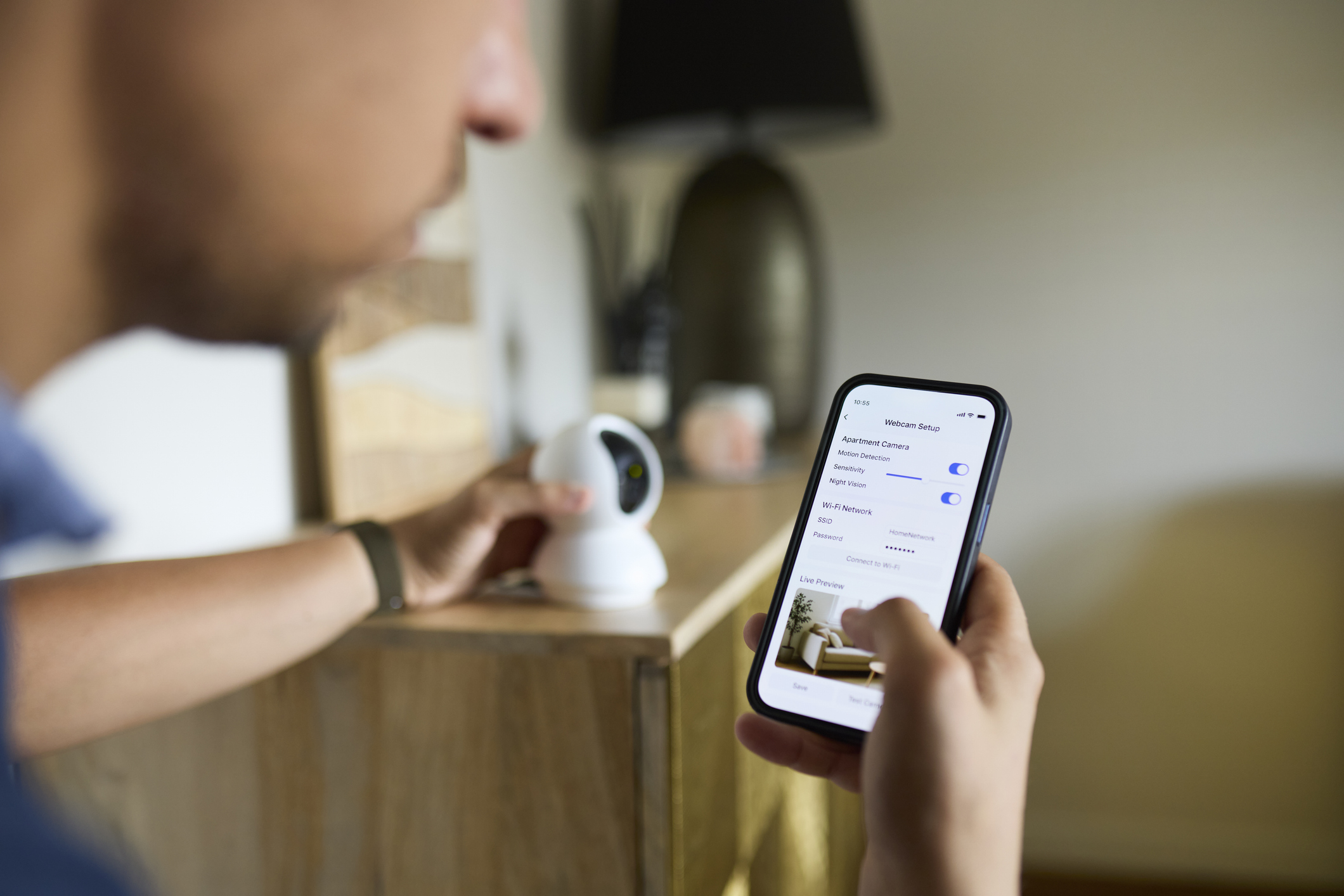 Man Setting Up Smart Webcam Using Smartphone at Home