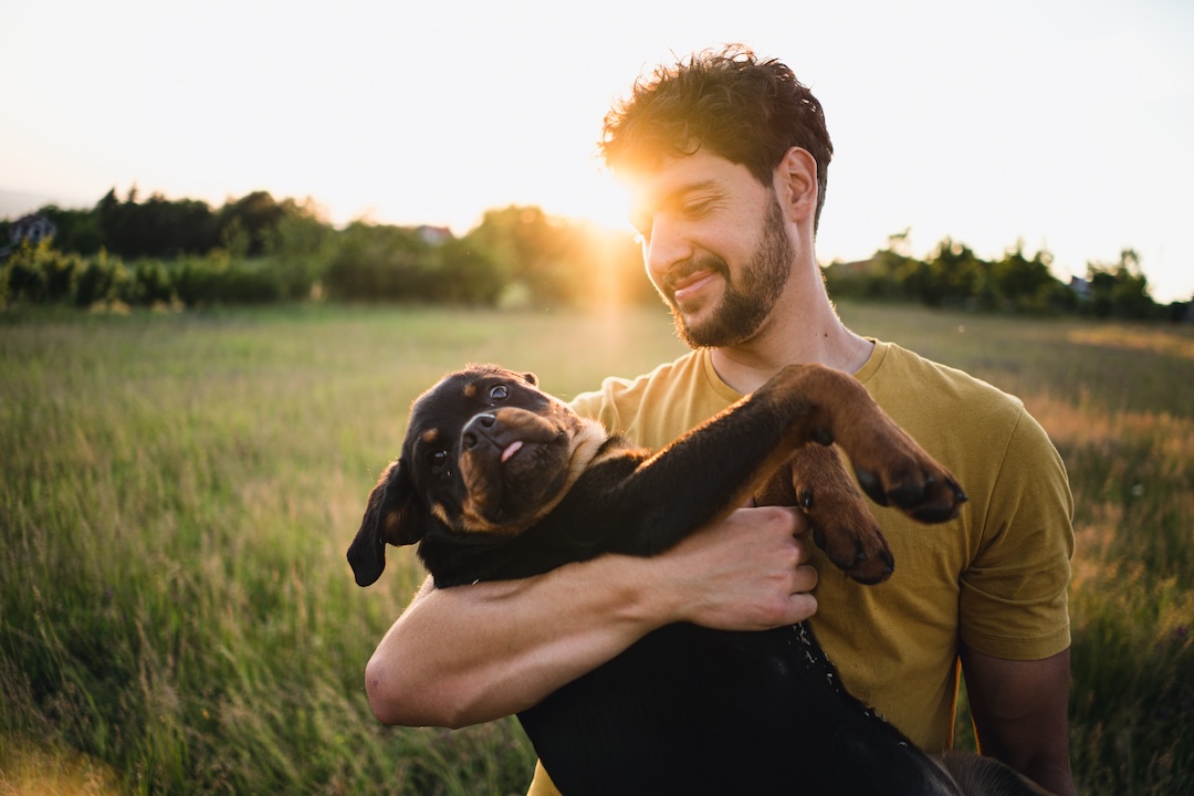 A man holding a Rottweiler puppy