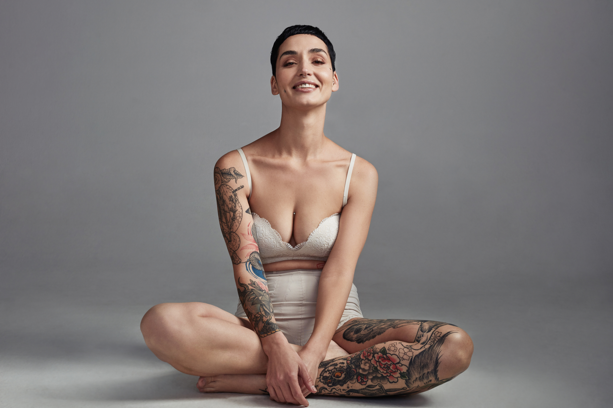 Shot of a young woman posing in her underwear against a grey background