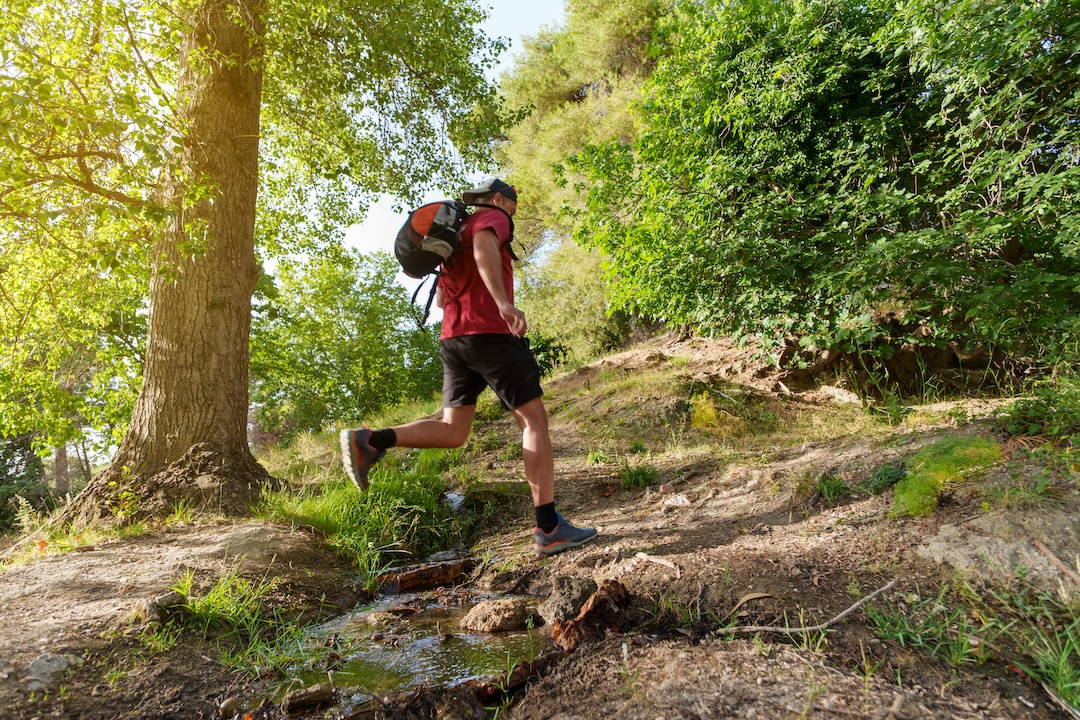 Wide shot of mid adult man practicing rucking in the mountain at sunset