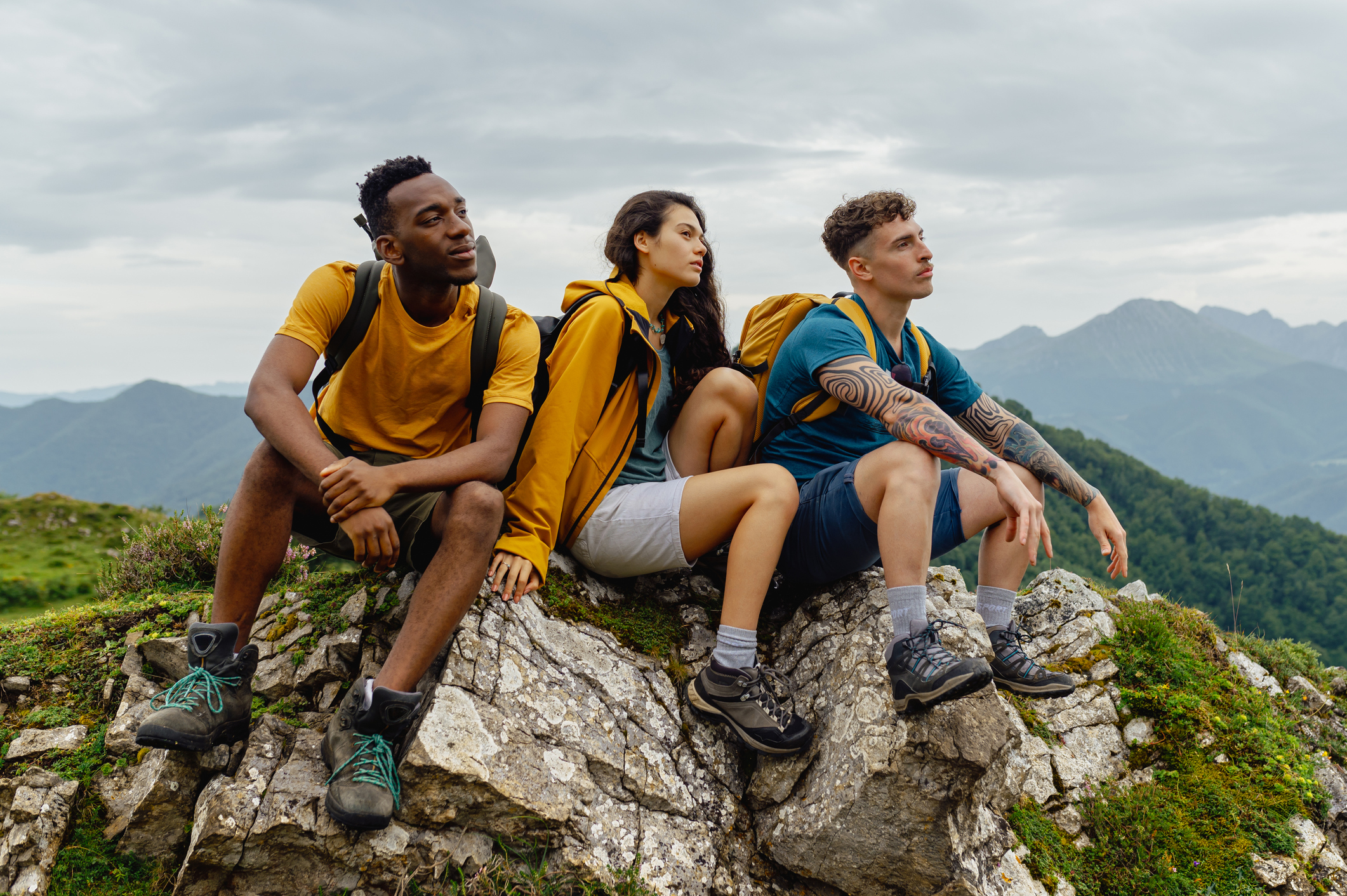 Hikers resting and enjoying mountain view after reaching peak