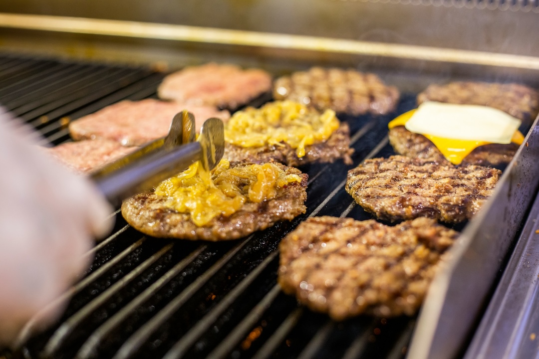 Person flipping burgers