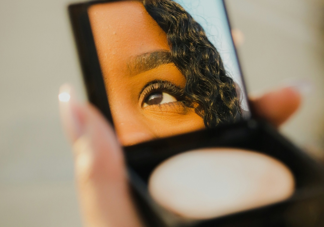 Woman looking into a compact mirror