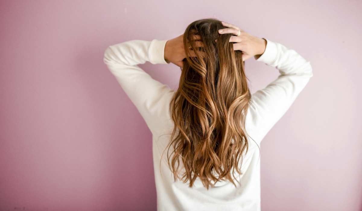 Woman styling hair with Dyson hair care tools from the Labor Day sale