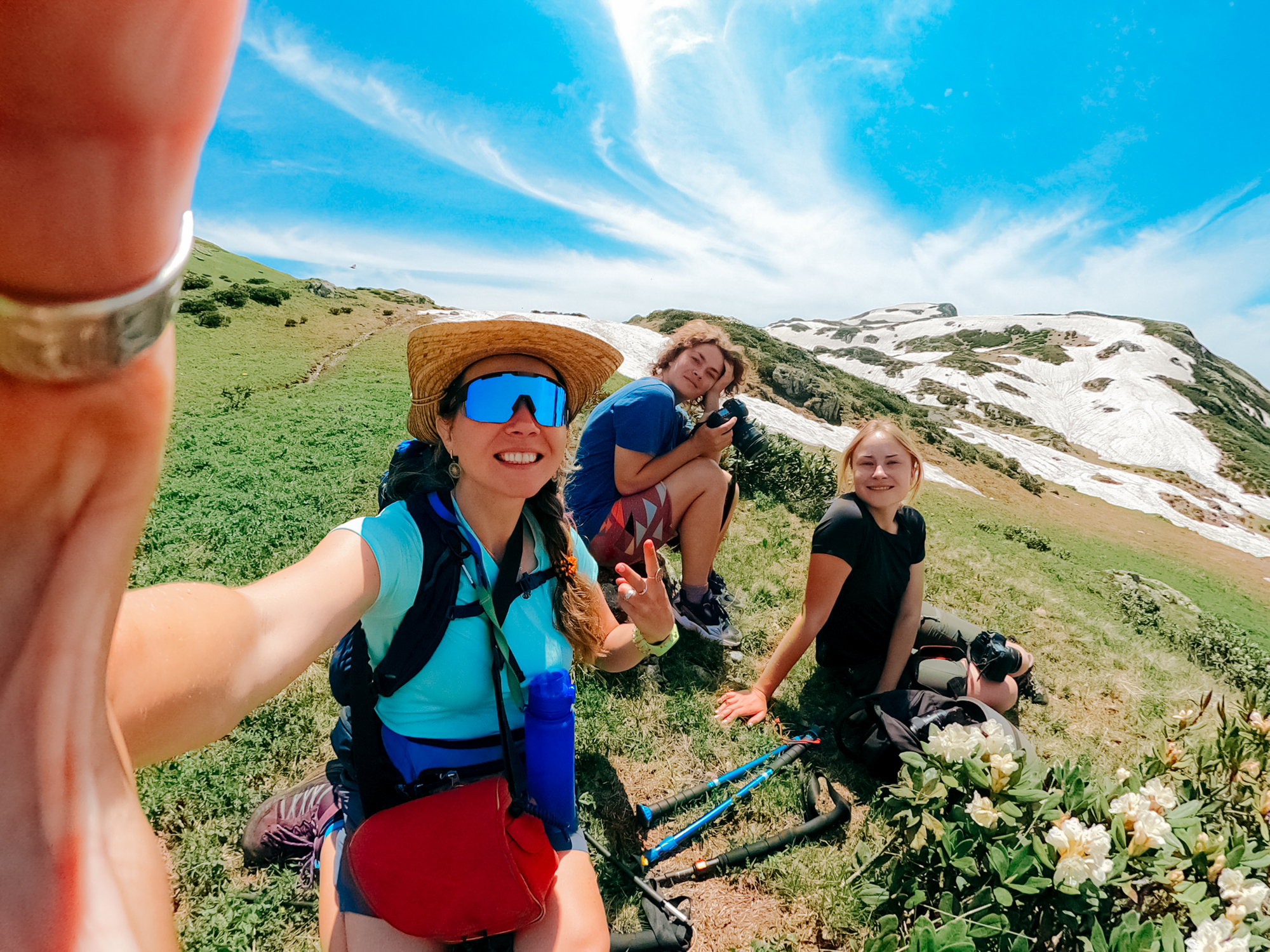 Female friends hikers relax during a hike in the mountains and take selfie.