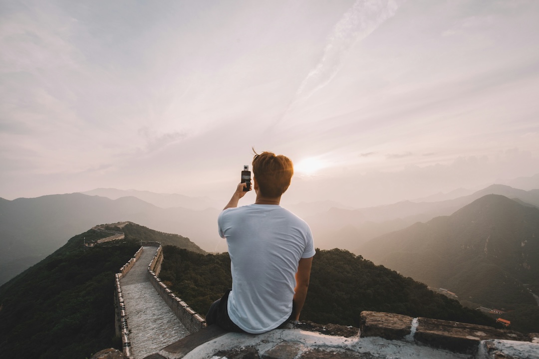 Man traveling with phone using universal adapter