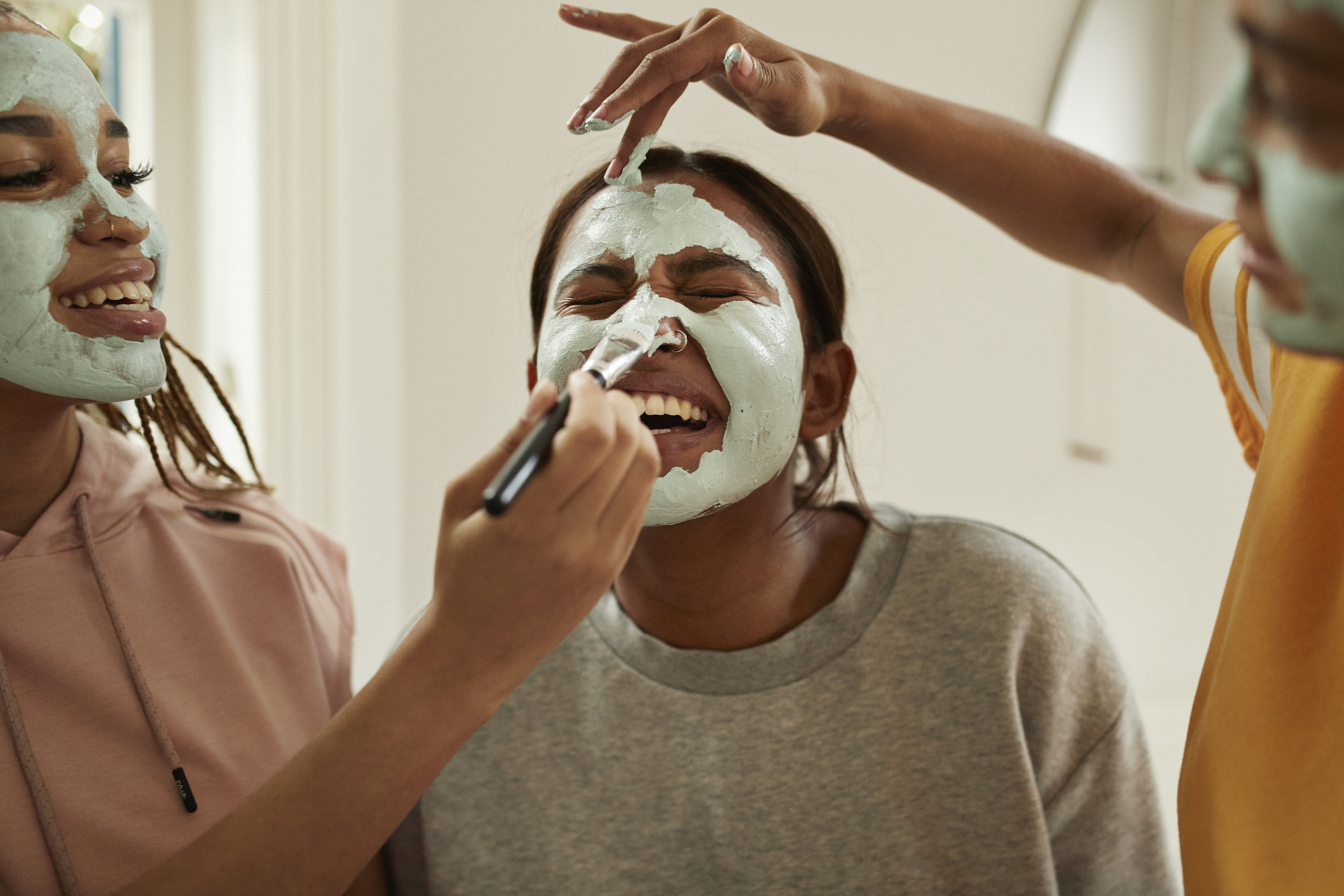 Women applying face masks in the bathroom