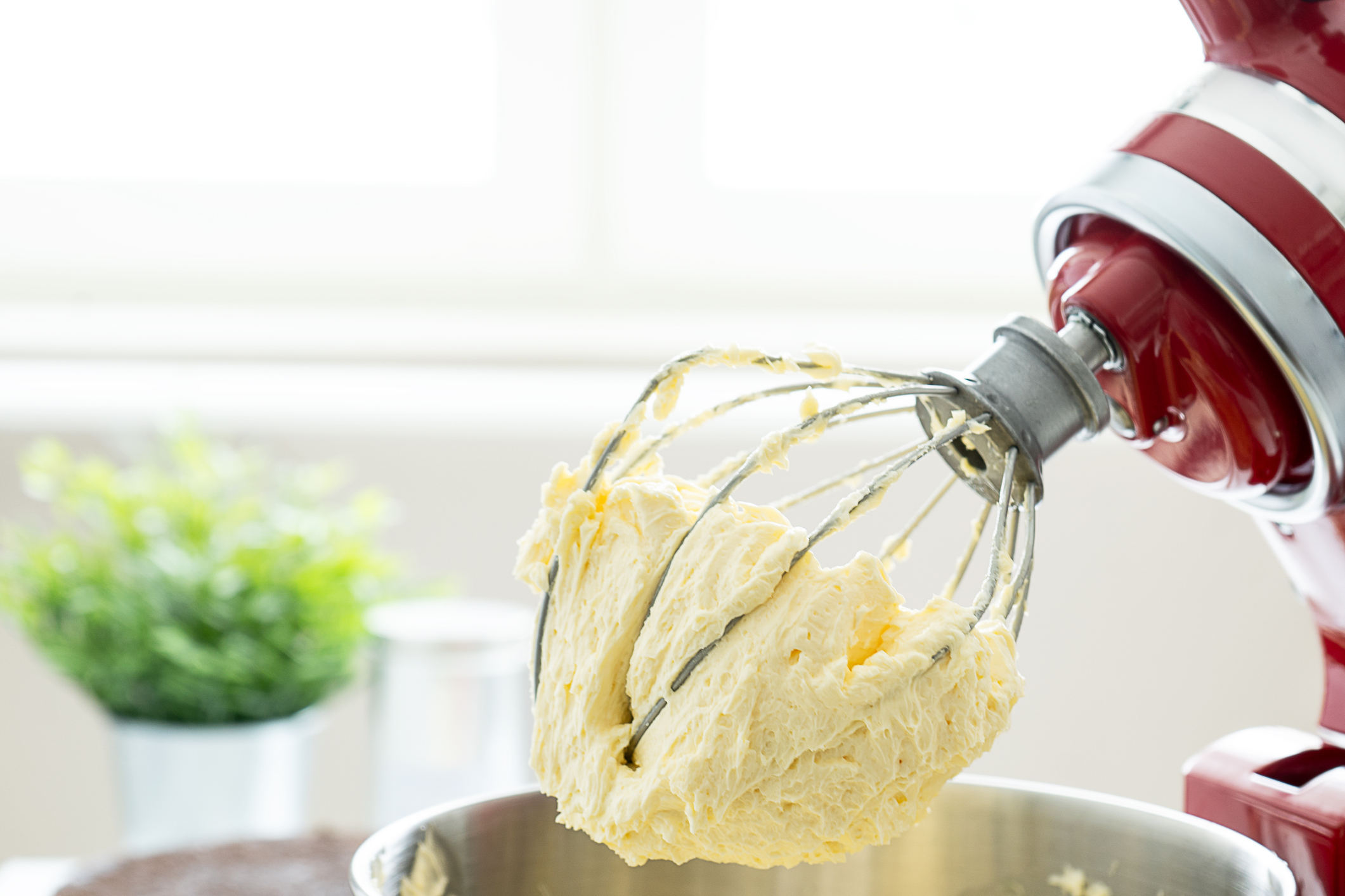 A close-up of batter and a whisk attached to a mixer.