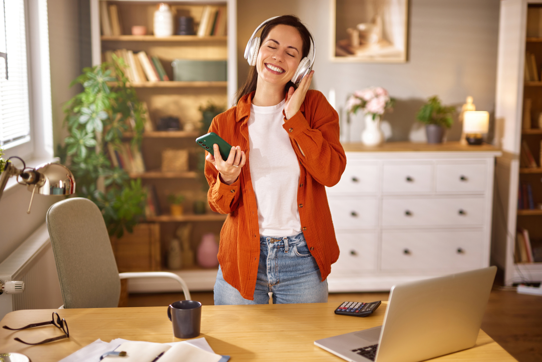 Happy businesswoman enjoying music during a break from work in her home office