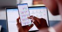 Woman Organizing Appointment Schedule Using Cellphone And Calendar