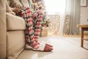 Young women sitting at the end of the sofa in home slippers and pajamas.