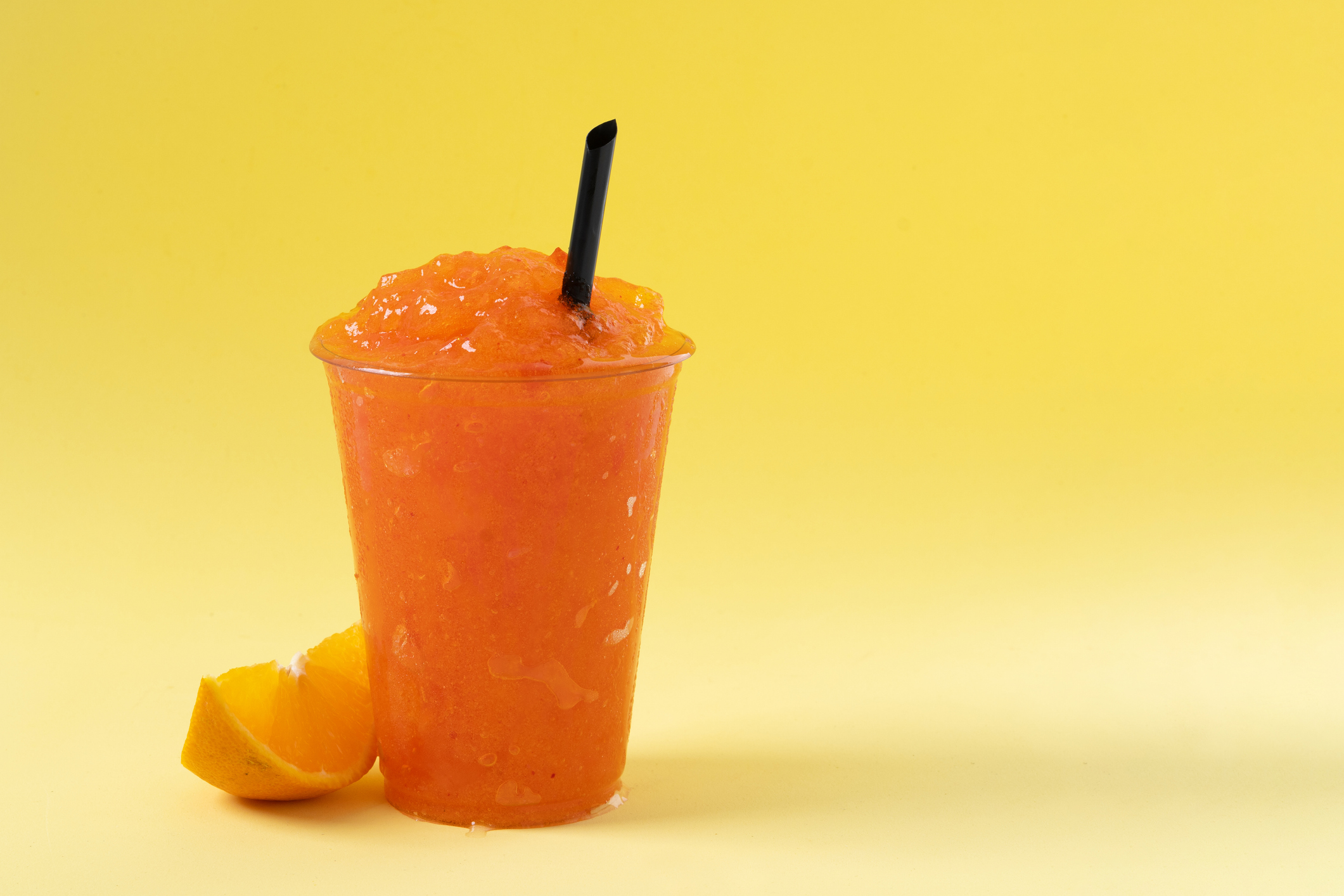 Orange slushie on yellow background.