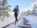 A woman exercising by running outdoors in winter.