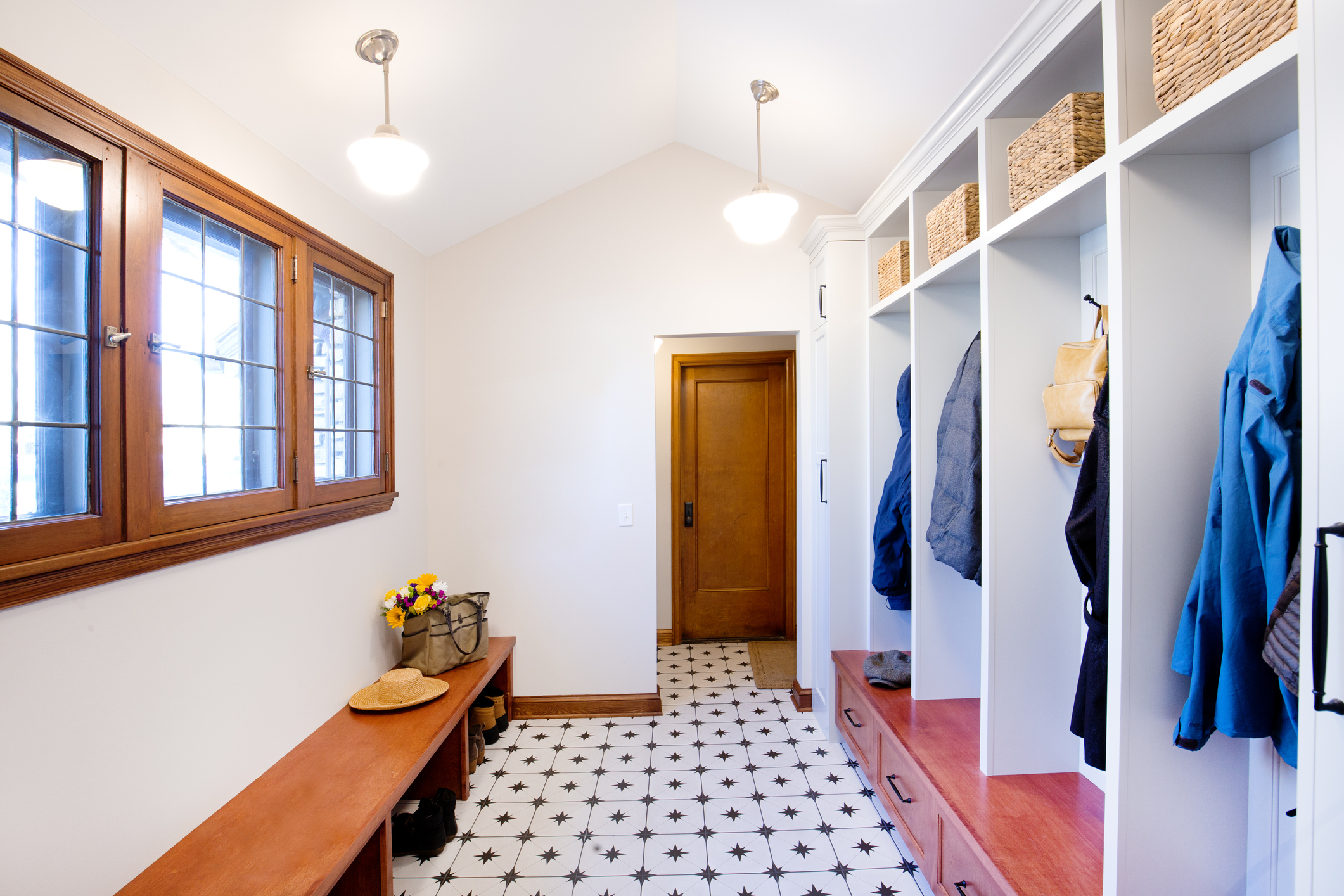 The entry wall of a residential home, a mudroom where coats are stores, a place to put on shoes and general storage and closets