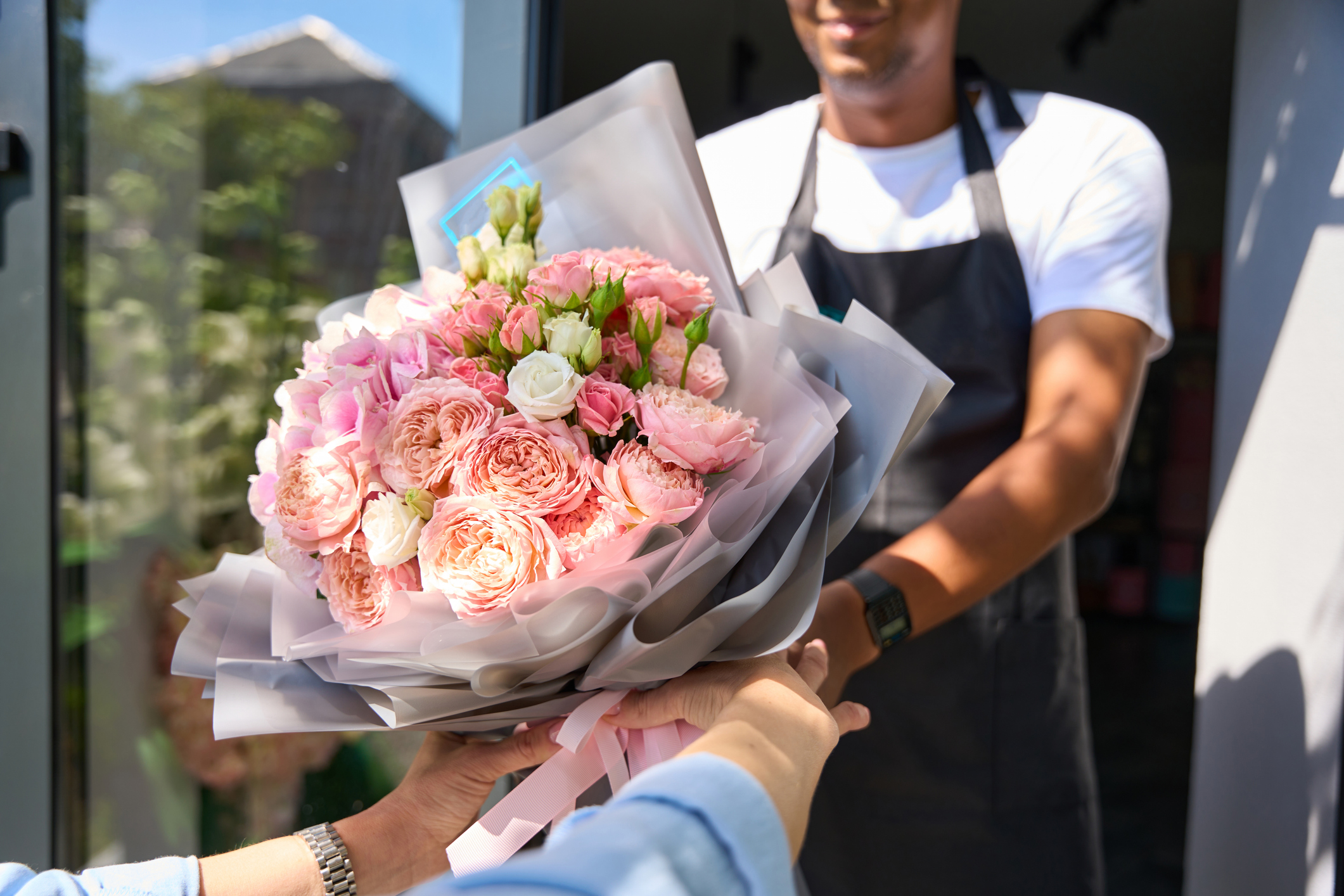 Woman buyer takes a beautifully formed bouquet in colored wrapping paper
