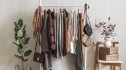 Cozy dressing room. Floor hanger with women's seasonal autumn winter clothes. Coats, pullovers, jackets, shirts, shoes - comfortable casual women's clothing