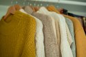 Warm autumn clothes knitted in the closet. Organization.