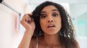 Portrait of an attractive young woman applying mascara in the bathroom