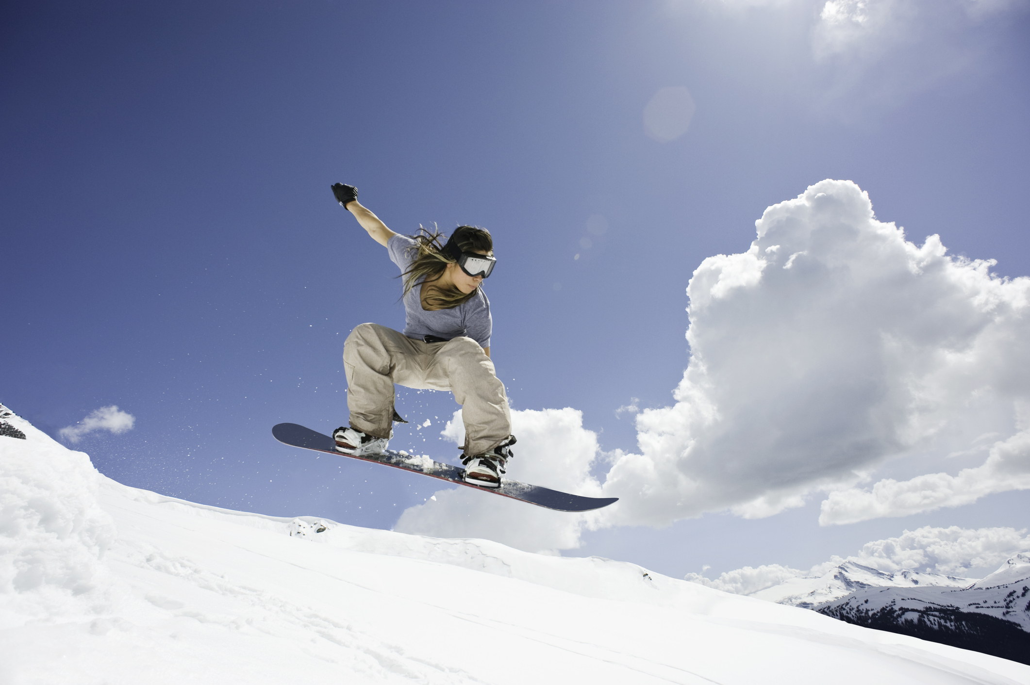 Female snowboarder jumping through air