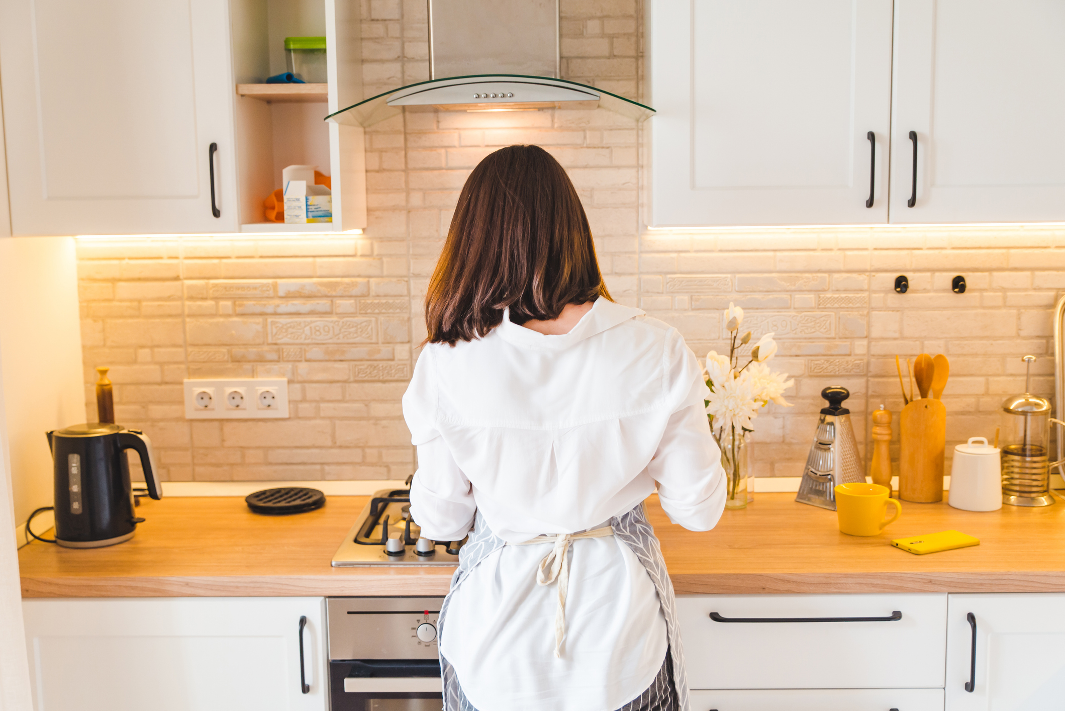view from behind woman on kitchen cooking housewife
