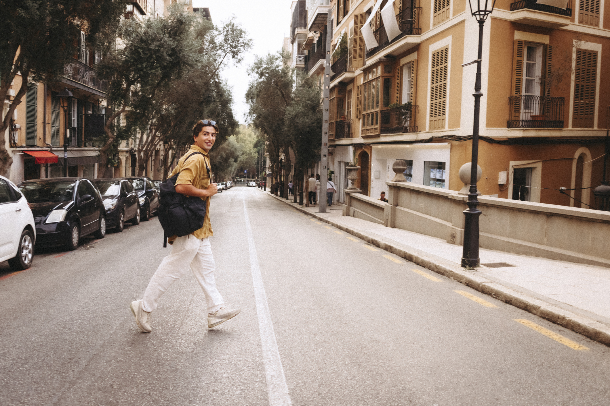 Side view of male tourist crossing road in city