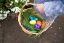 Child carrying basket of Easter eggs