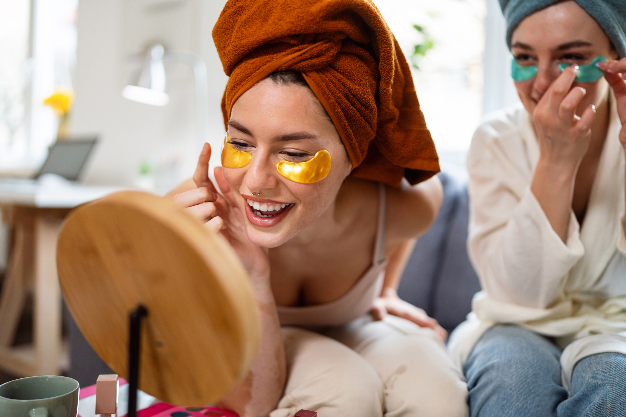 Two young women, roommates, doing beauty routine at their shared apartment.