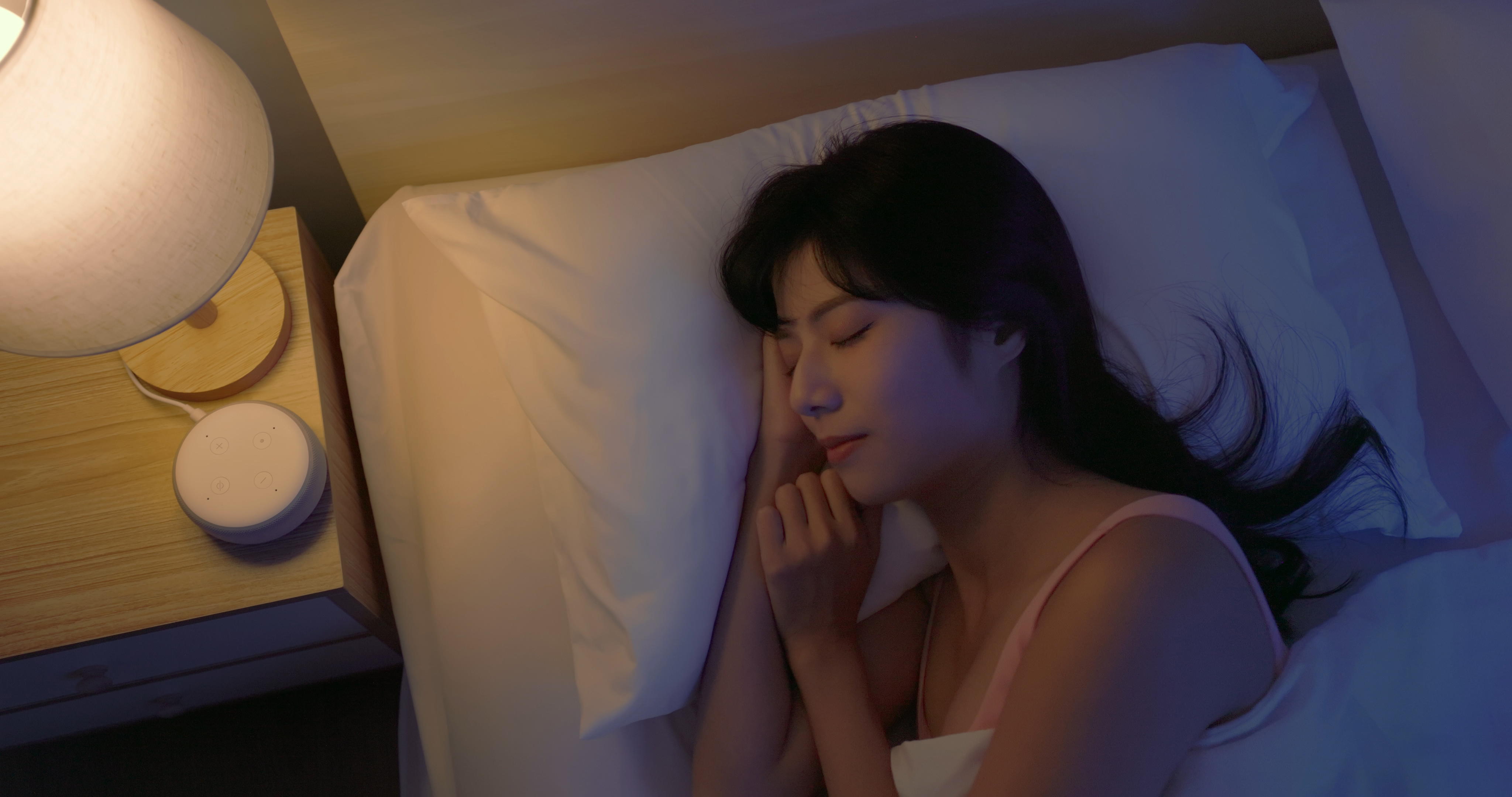Closeup top view asian woman lying on bed using white noise machine helping sleeping quality at night