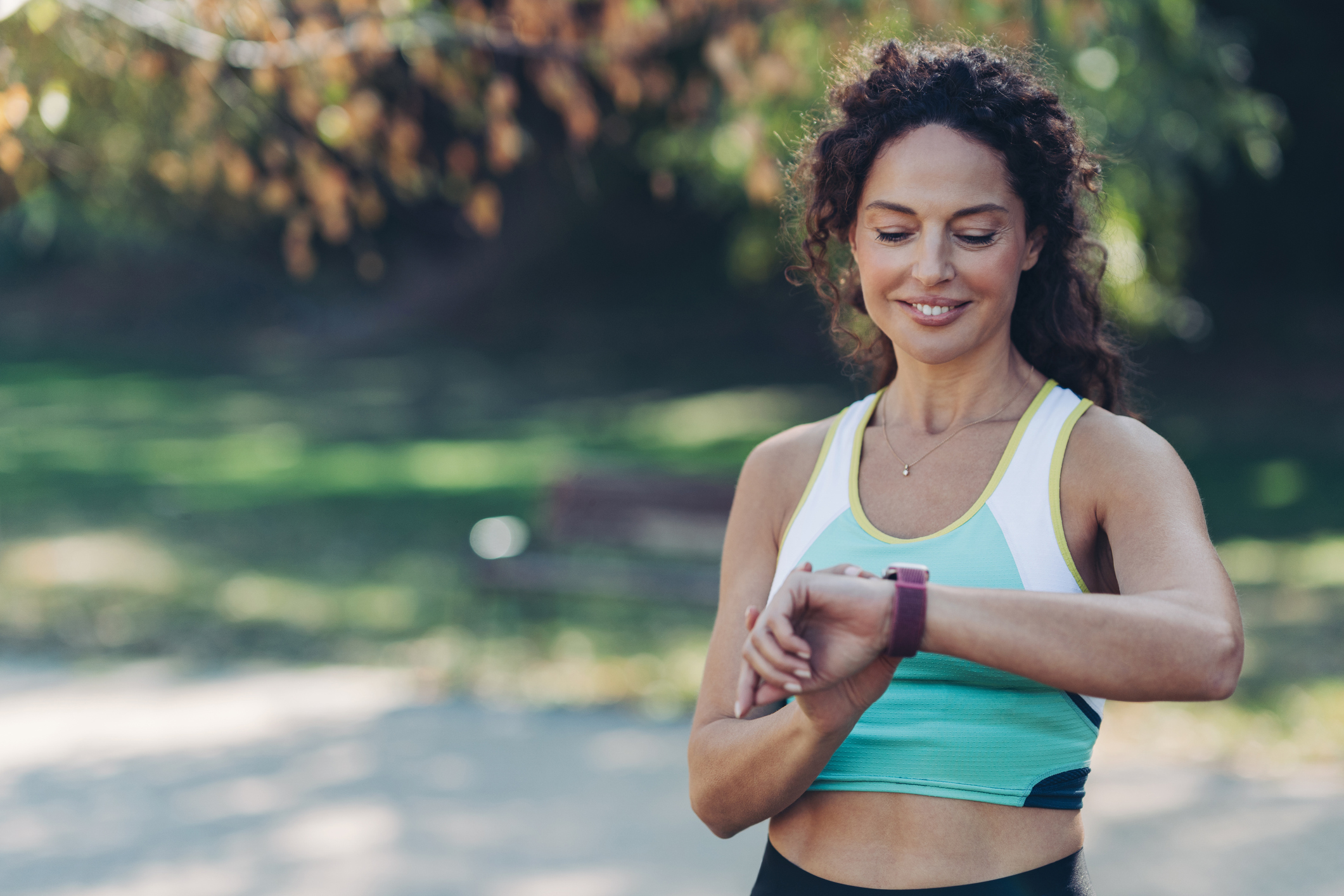 Portrait of a middle age athlete training in the park with one of the best fitness trackers under $100.
