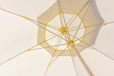 A large open outdoor umbrella of beige color. Umbrella for protection from the bright sun on the beach, cafe, patio, terrace. Realistic photo