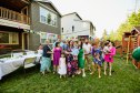 Wide shot portrait of multigenerational family during backyard birthday party on summer evening