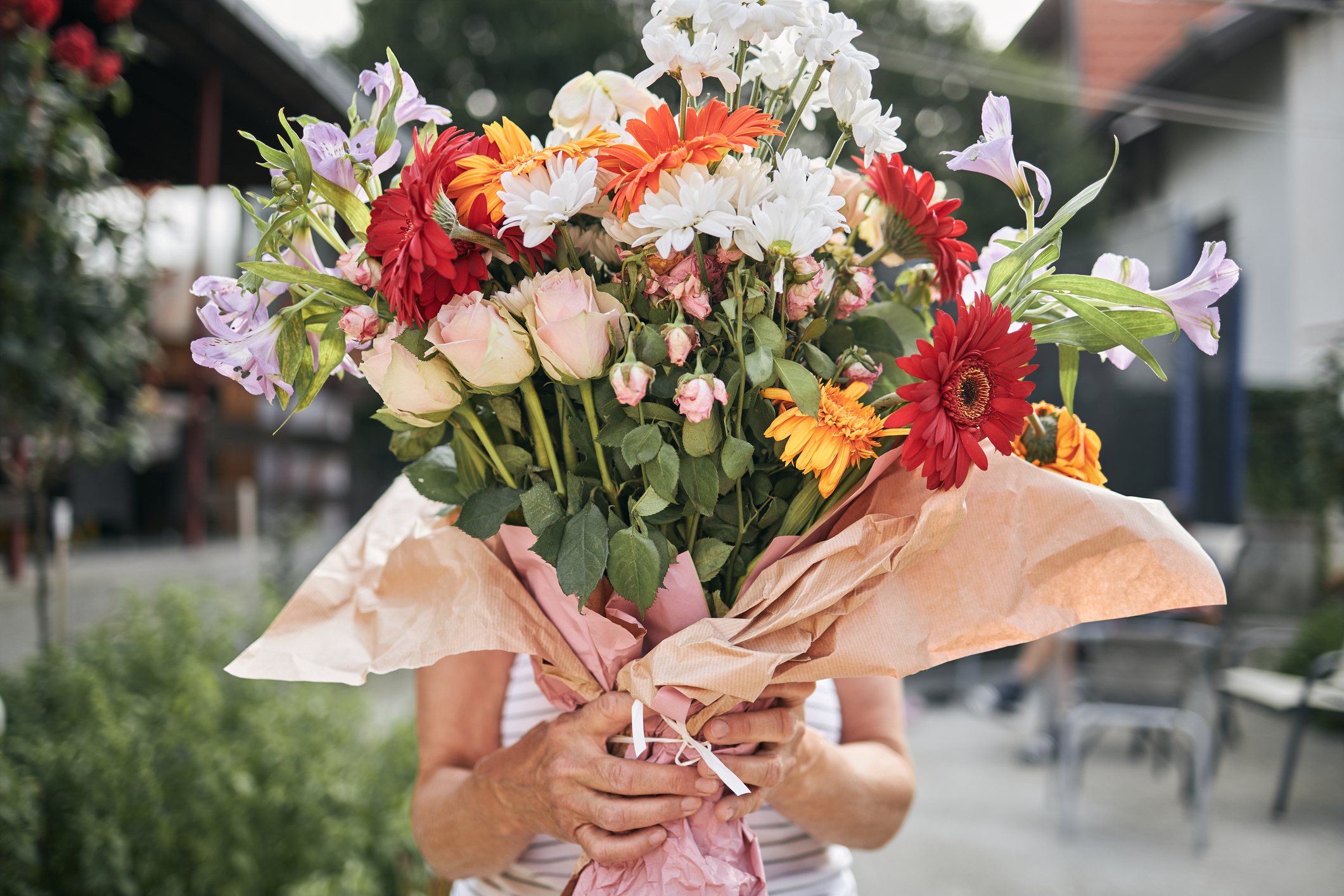 Senior woman is holding flower arrangement on mother’s day.