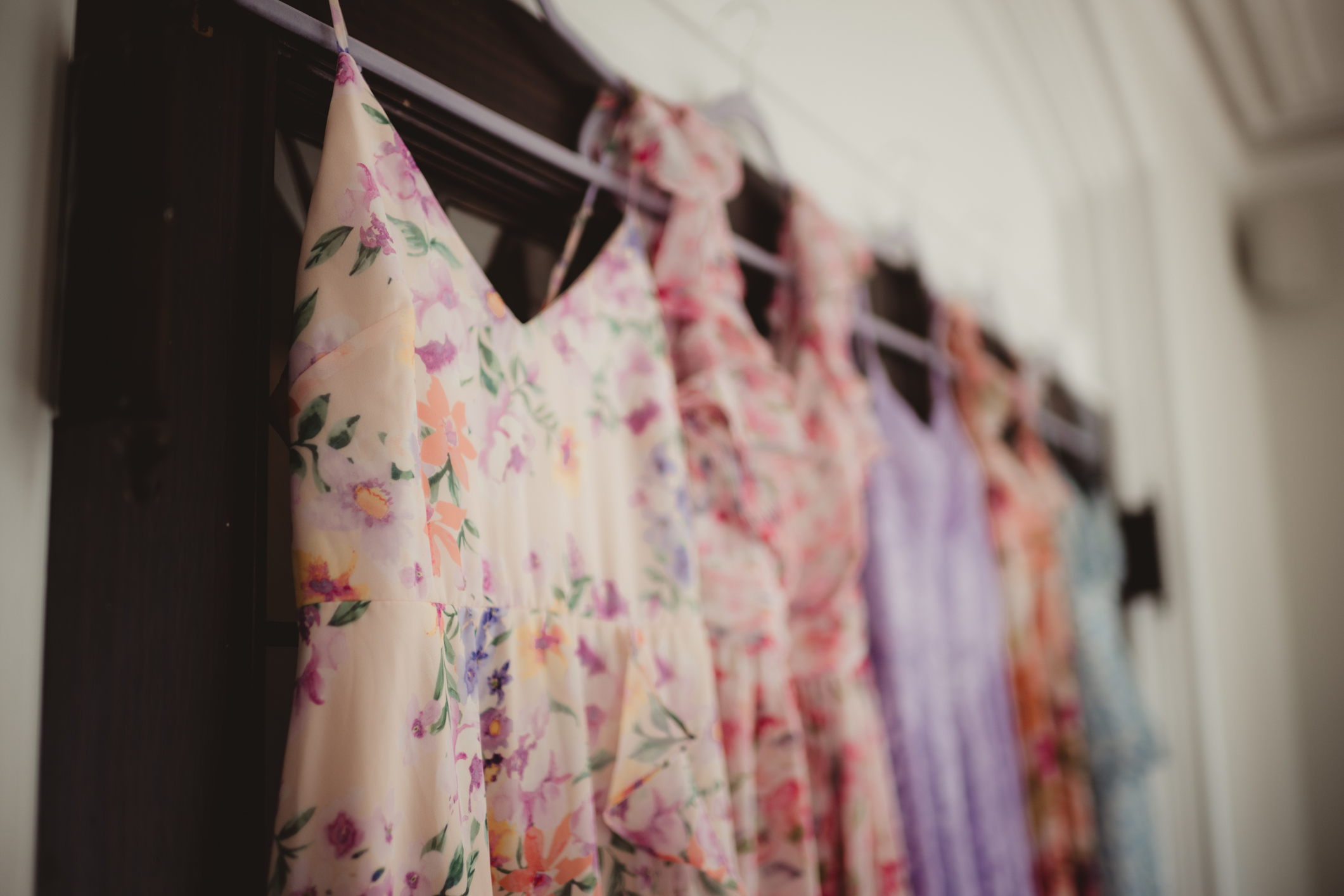 dresses in pastel floral colors hanging up