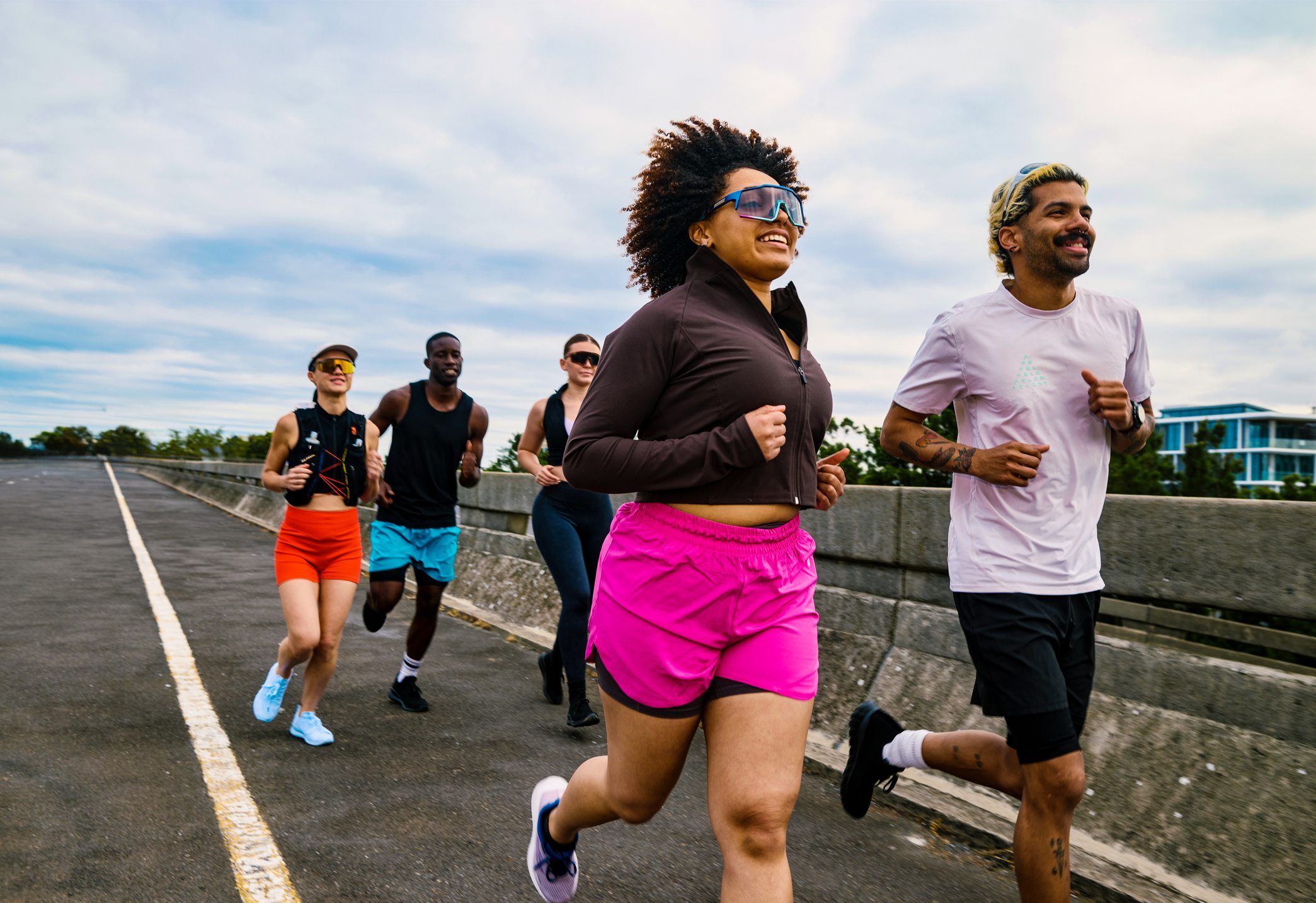 Diverse friends running on a city street, enjoying urban fitness and an active lifestyle