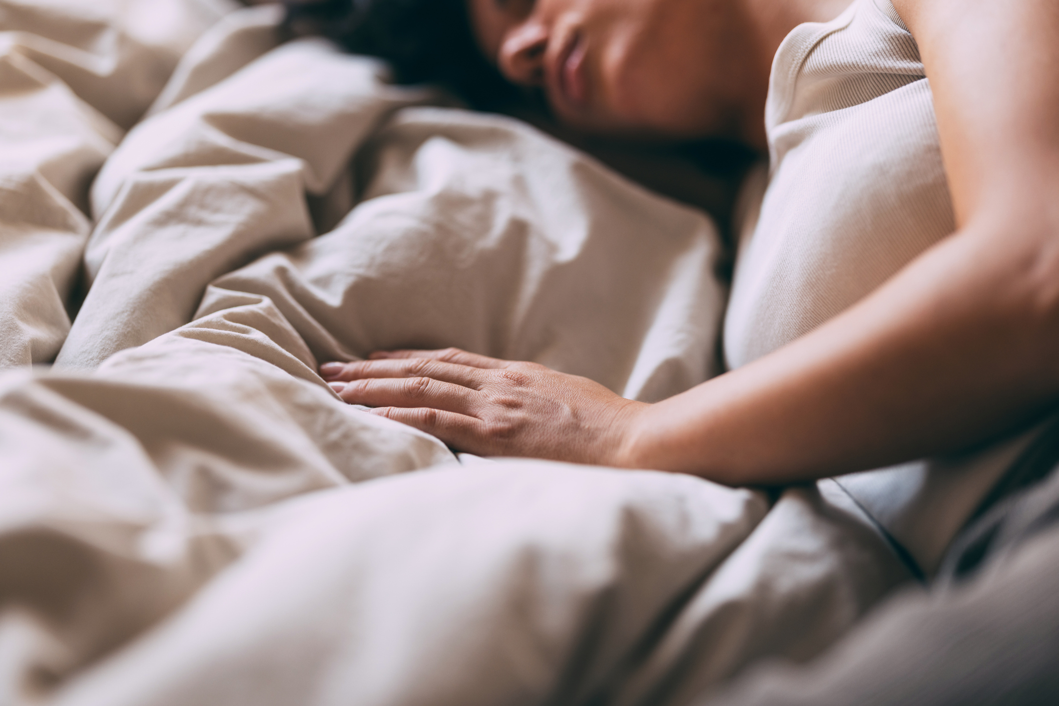 A serene image of a woman sleeping peacefully in bed, conveying comfort and rest. The soft lighting and cozy setting create a calm and relaxing atmosphere.