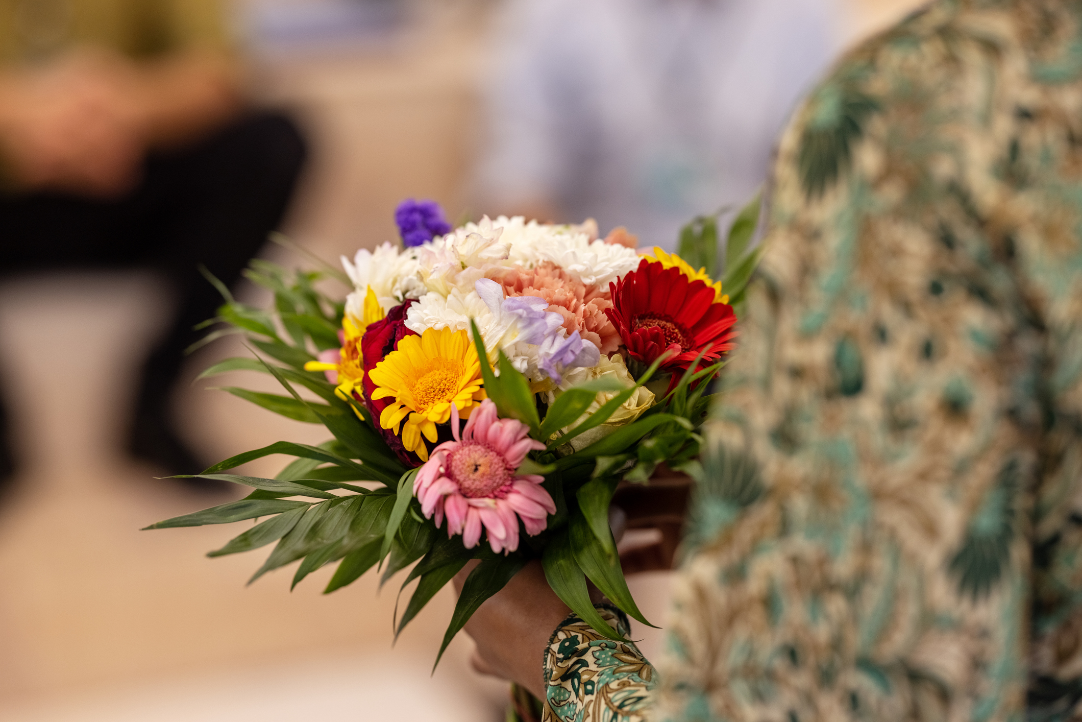 Close-up of a woman holding flowers at the seminar. Woman holding bouquet at a meeting in office.