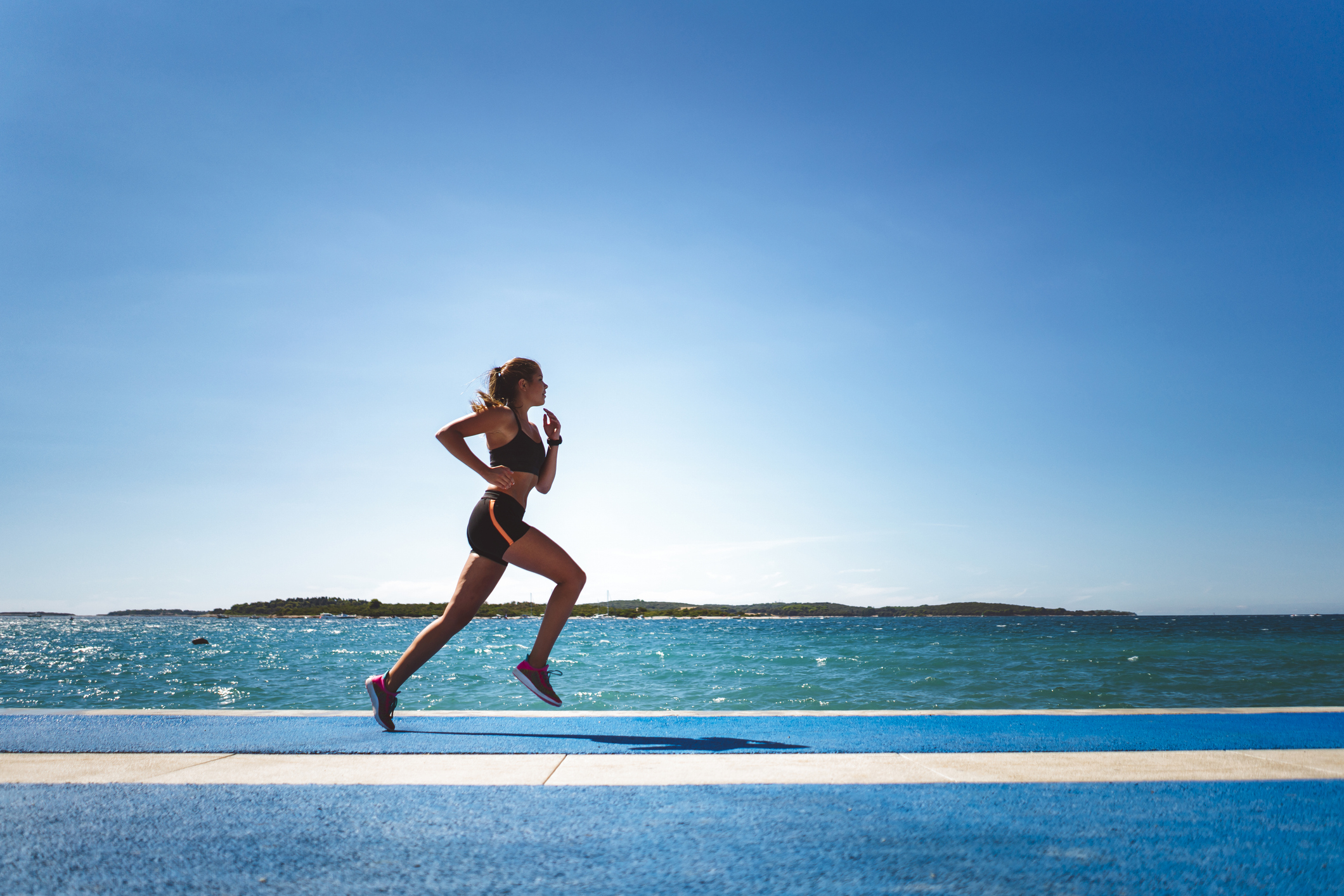 Young woman exercising at the beach, staying fit in the summer