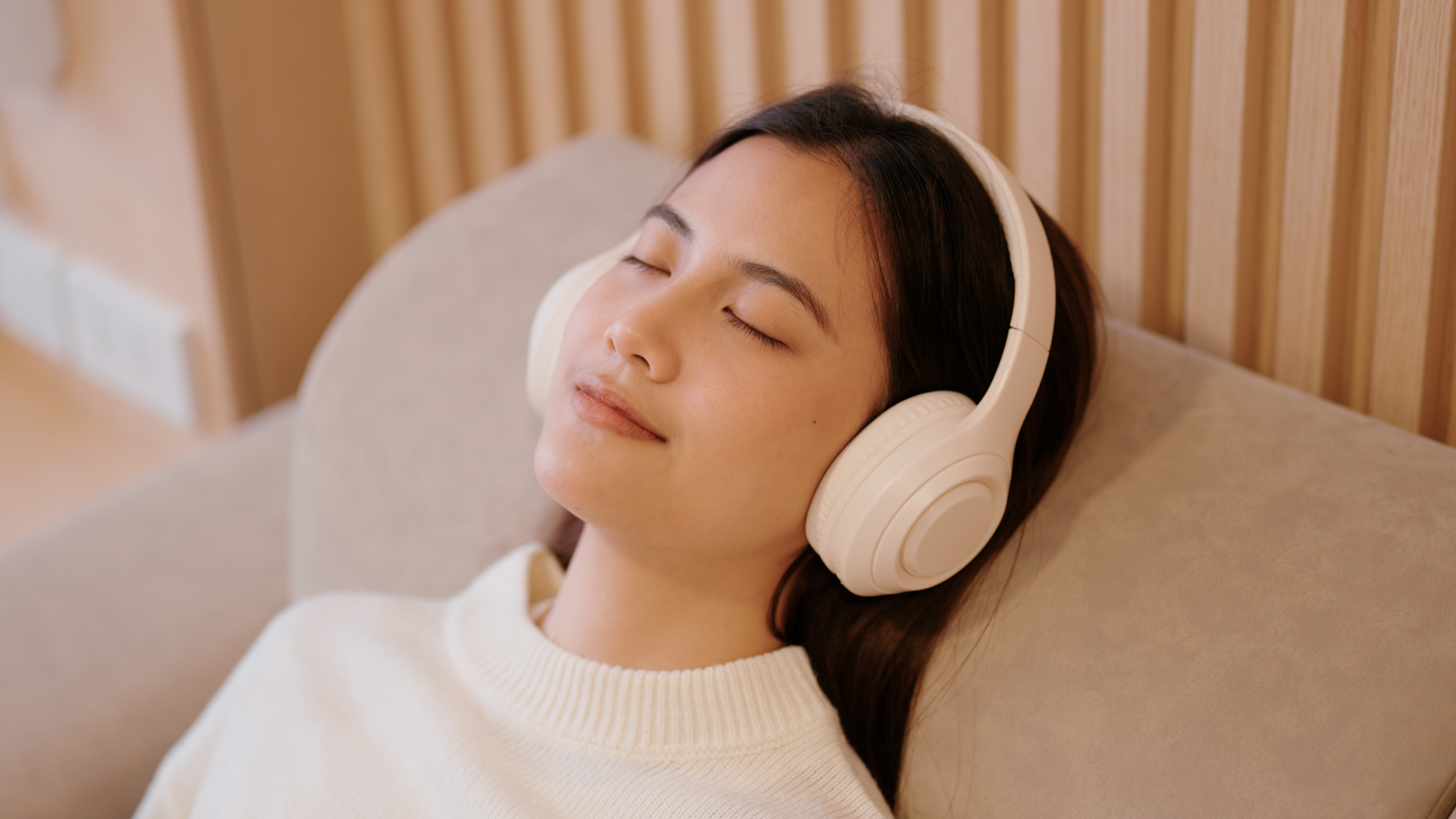 Taking a relaxing nap on a comfy sofa with wireless headphones and gear from the Renpho Mother's Day sale