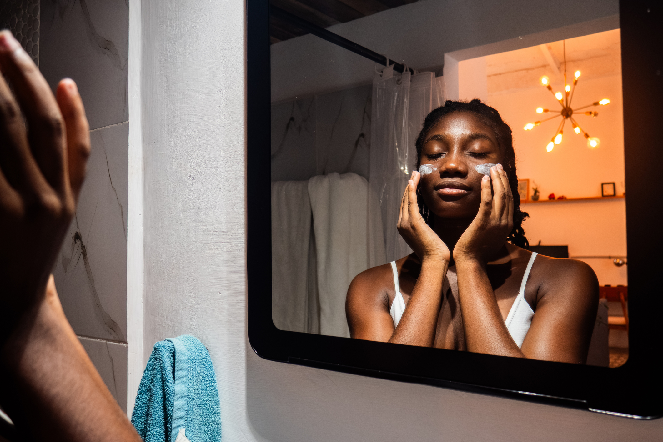 Young woman applying cream to her face